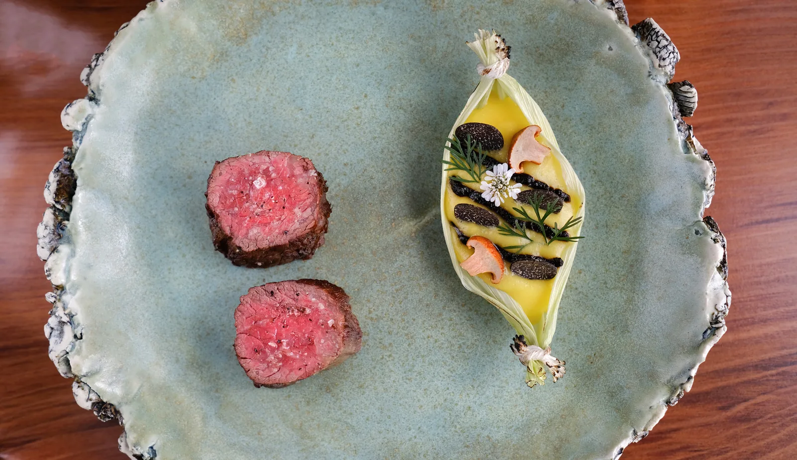Tasting menu course at Aubergine, Carmel, with seared beef medallions on a speckled stoneware plate, food photography by Manny Espinoza