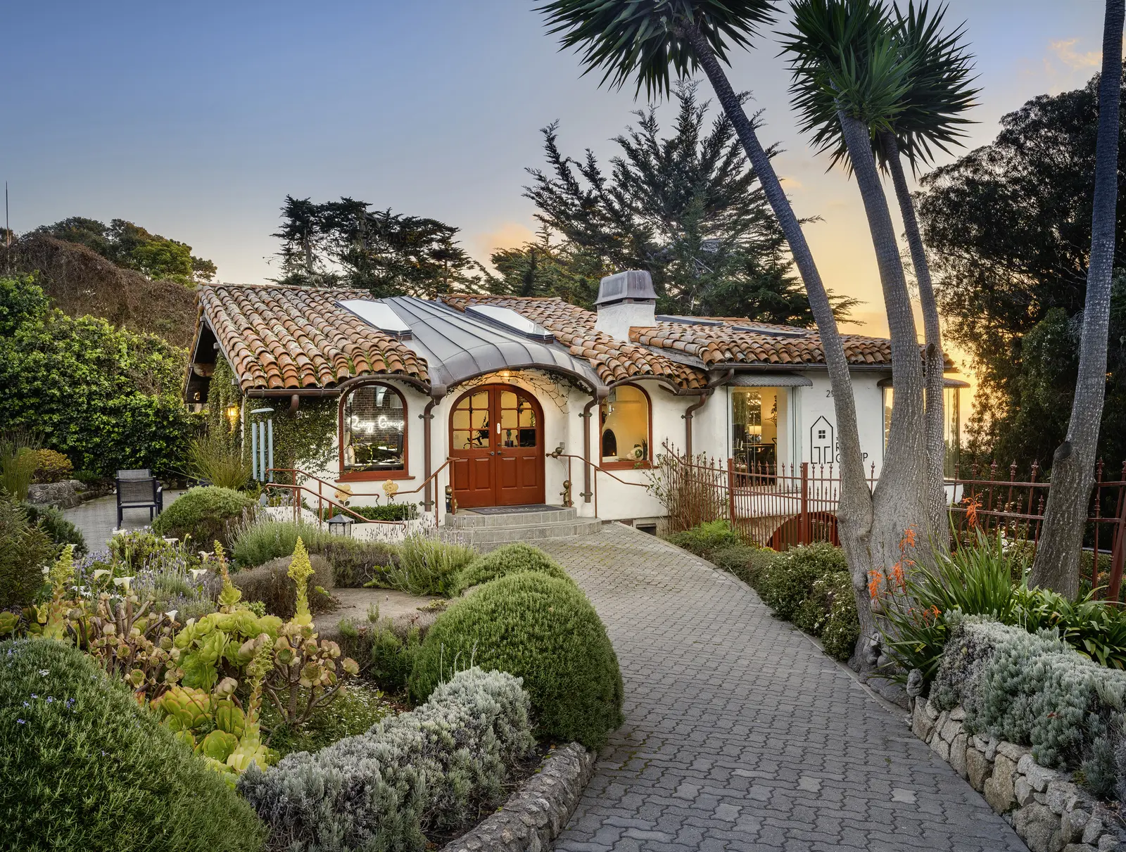Storybook Carmel cottage at twilight with lush landscaping — architectural photography by Manny Espinoza