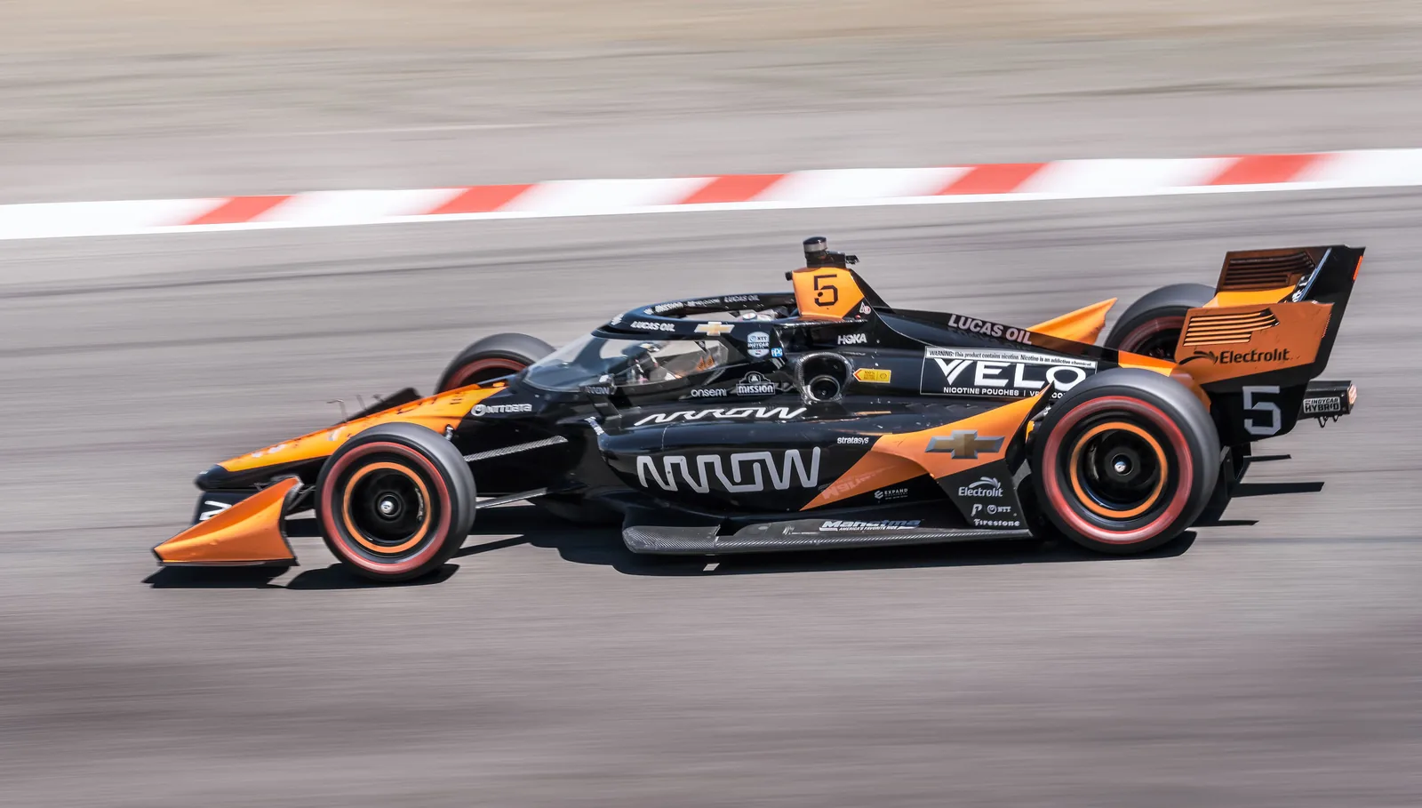 IndyCar race car at speed on track, motorsport photography by Manny Espinoza