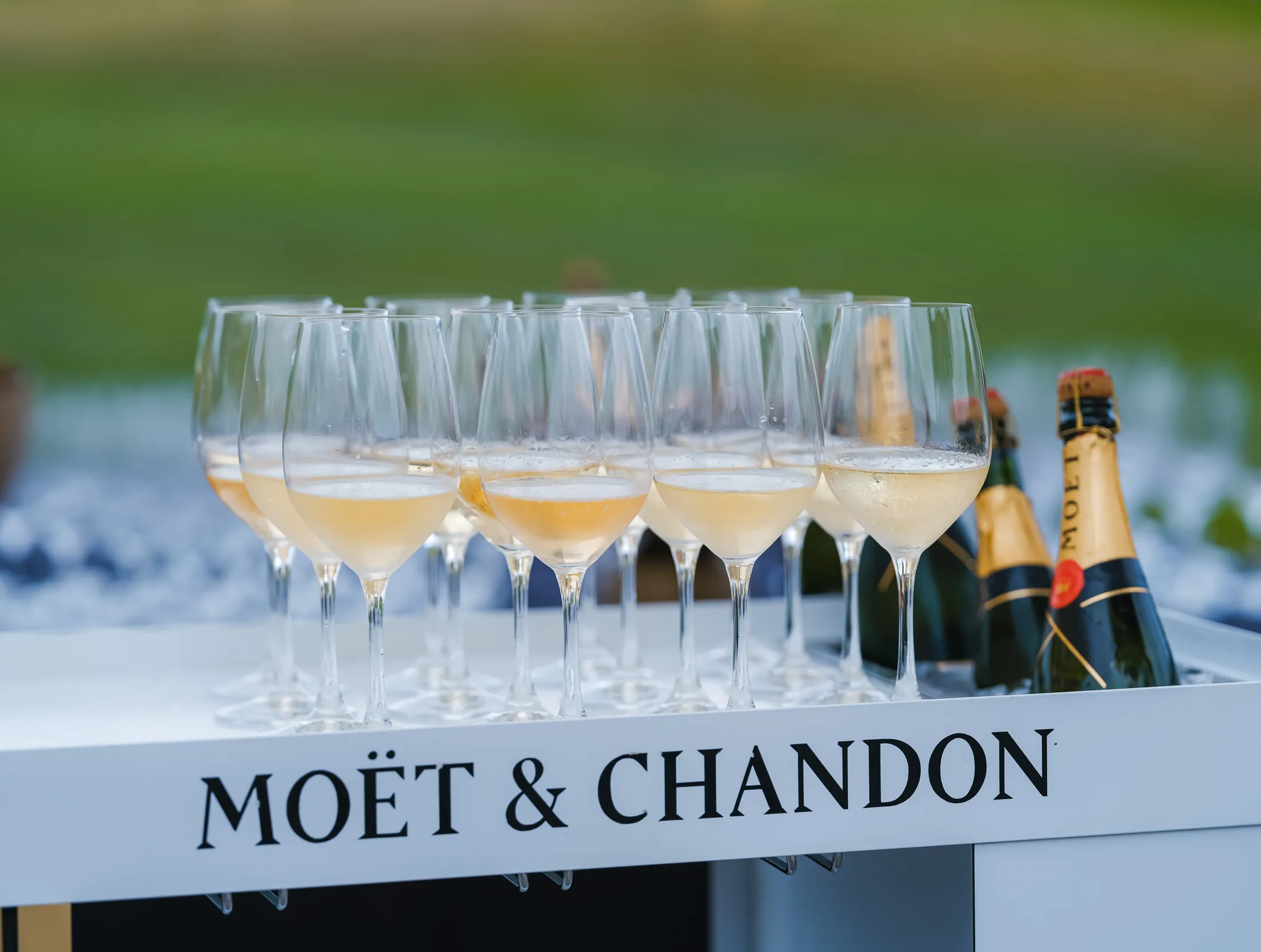 Moët & Chandon champagne glasses lined up on a branded bar at the Lamborghini Serata Italiana during Monterey Car Week