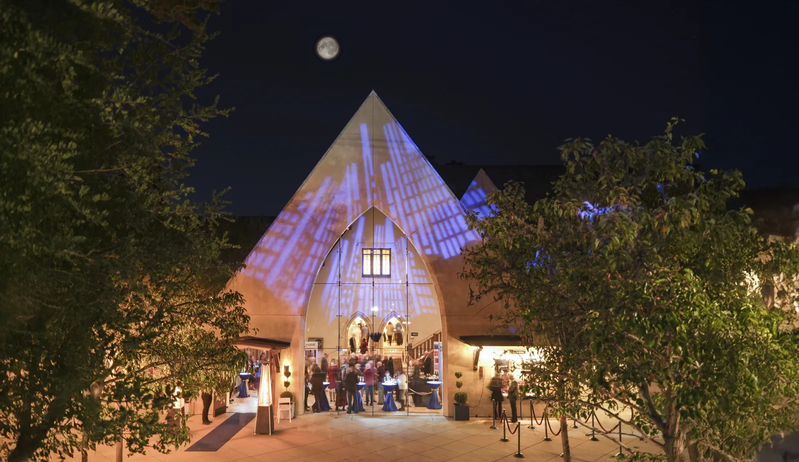 Monterey Symphony venue glowing at night beneath a full moon, event photography by Manny Espinoza