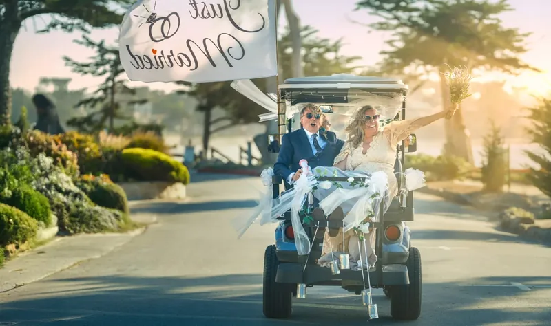 Just-married couple celebrating in a decorated golf cart on Scenic Drive, Carmel-by-the-Sea