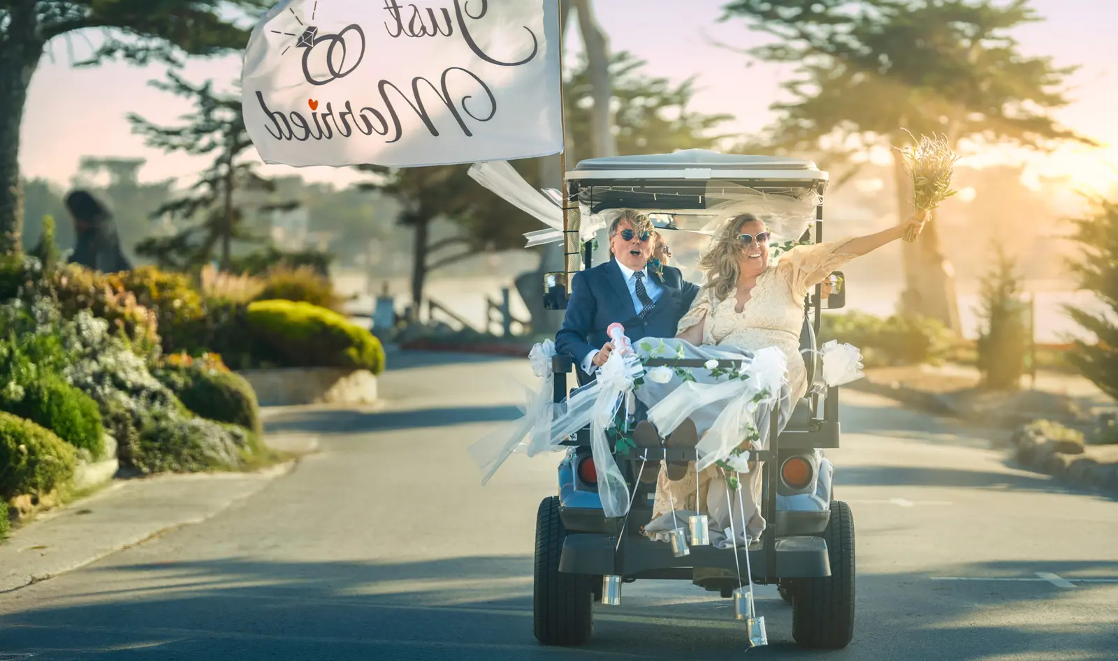 Just-married couple in a golf cart on Scenic Drive, Carmel — wedding photography by Manny Espinoza
