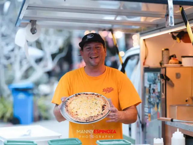 Pizza truck chef holding a freshly baked pizza at Taste of Carmel 2026