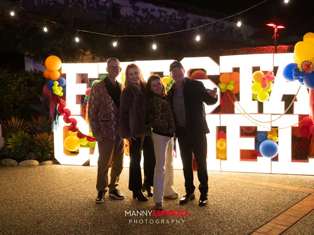 Guests posing in front of the lit FIESTA CARMEL sign and balloons at Taste of Carmel 2026