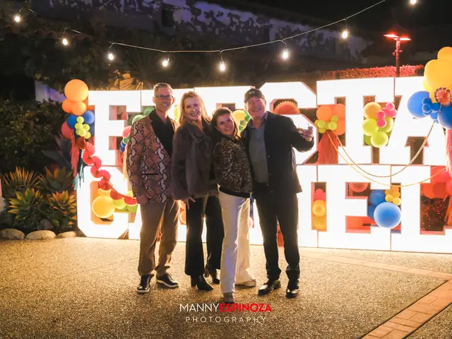 Guests posing in front of the lit FIESTA CARMEL sign and balloons at Taste of Carmel 2026