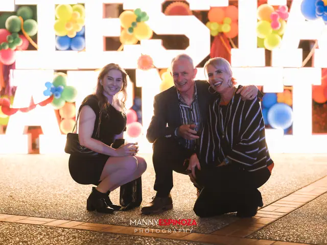 Three guests crouching in front of the glowing FIESTA CARMEL sign at the end of Taste of Carmel 2026