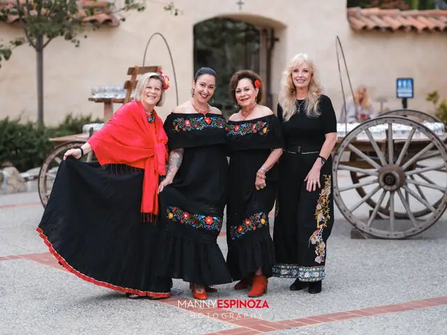 Women in embroidered Mexican dresses beside a wooden wagon at Taste of Carmel 2026