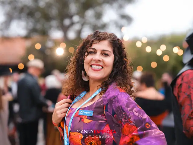 Woman in a purple floral kimono and Chamber lanyard smiling at Taste of Carmel 2026