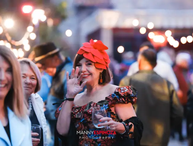 Woman in a red flower headpiece waving at Taste of Carmel 2026