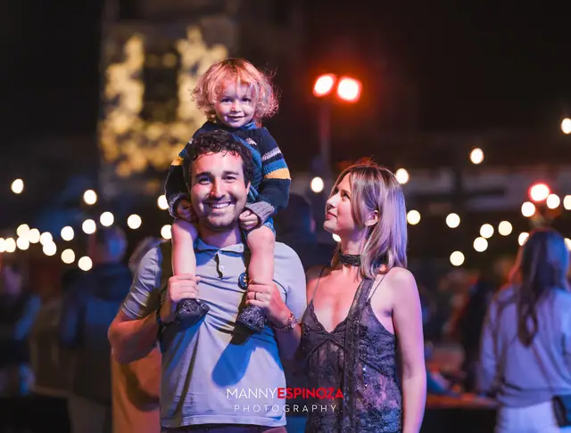 A child on his father's shoulders with his mother beside them under string lights at Taste of Carmel 2026