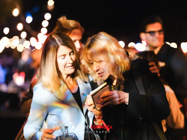 Two women laughing over a phone at Taste of Carmel 2026