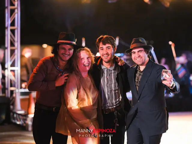 Group of four guests posing under the stage truss at Taste of Carmel 2026