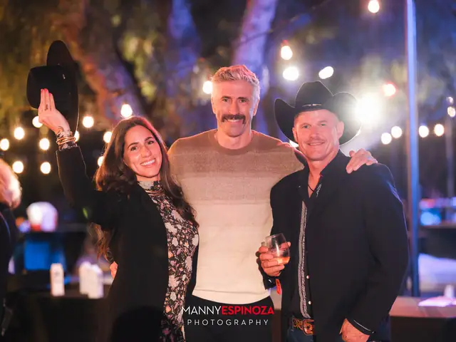 Three guests posing, one holding up a black hat, at Taste of Carmel 2026