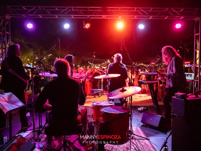 The band on stage under purple and red lights, seen from behind the drum kit, at Taste of Carmel 2026
