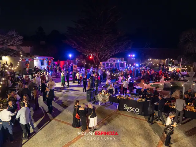 Elevated view of the crowd, vendor booths and string lights in the Carmel Mission courtyard at Taste of Carmel 2026