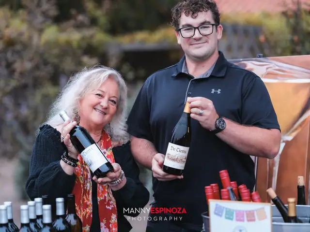 Winemakers holding bottles at their tasting table at Taste of Carmel 2026