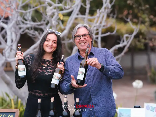 Winemakers holding bottles at their tasting table at Taste of Carmel 2026