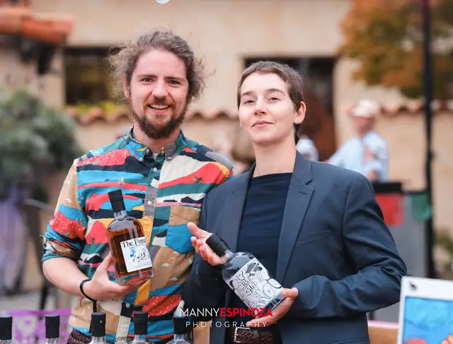 Two guests holding bottles of spirits at Taste of Carmel 2026