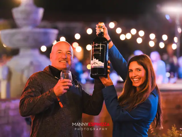 Guests holding a large wine bottle beside the courtyard fountain at Taste of Carmel 2026
