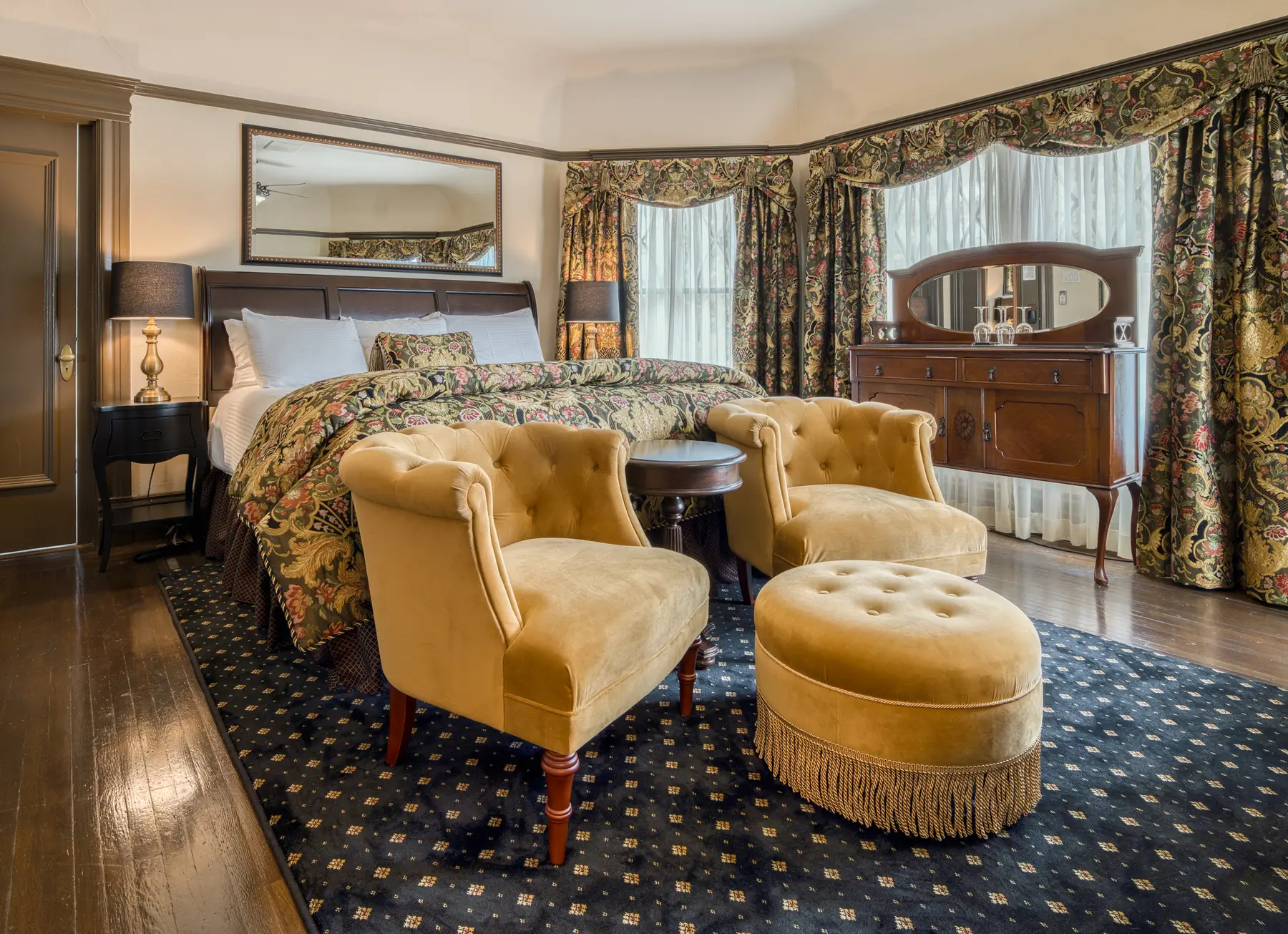Gold velvet tufted chairs and ottoman beside a bed at The Charles Napa Valley, Napa