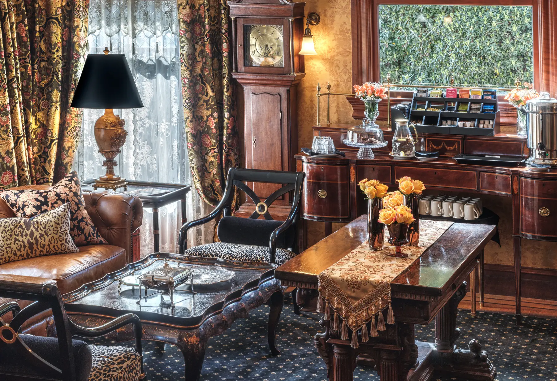 Parlor at The Charles Napa Valley with a grandfather clock and coffee service, roses on the table, Napa