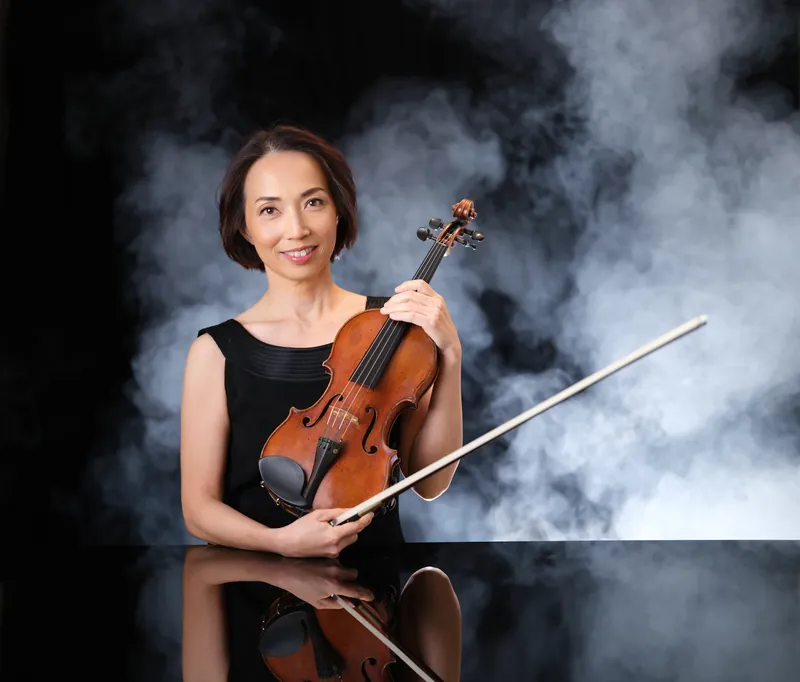 Violinist in a black dress holding her violin and bow in a studio with drifting smoke, musician portrait by Manny Espinoza