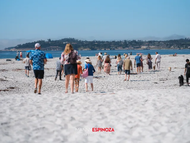 Guests walking across the sand toward the reception with Pebble Beach across the bay at Walk for Freedom 2026 on Carmel Beach