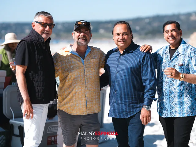 Four men in sunglasses with Carmel Bay behind them at Walk for Freedom 2026 on Carmel Beach