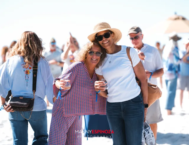 Four friends in sunglasses with glasses raised at Walk for Freedom 2026 on Carmel Beach