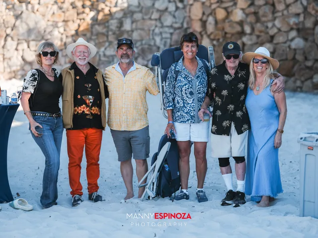 Five guests posing in front of the stone wall as the light turns gold at Walk for Freedom 2026 on Carmel Beach