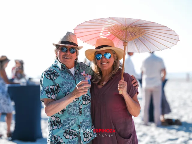 A couple under a pink paper parasol at Walk for Freedom 2026 on Carmel Beach