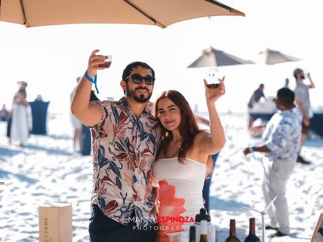 A couple taking a selfie at a pouring table at Walk for Freedom 2026 on Carmel Beach