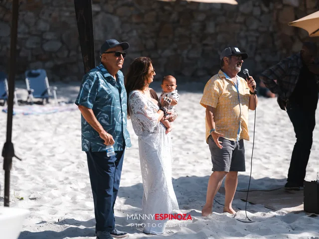 Event founders Jack Galante of Galante Vineyards and restaurateur Richard Pepe with Set Free Monterey Bay Executive Director Ashley Chesney, holding an infant, at the microphone at Walk for Freedom 2026 on Carmel Beach