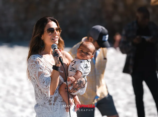 Set Free Monterey Bay Executive Director Ashley Chesney speaking to the crowd while holding a baby at Walk for Freedom 2026 on Carmel Beach