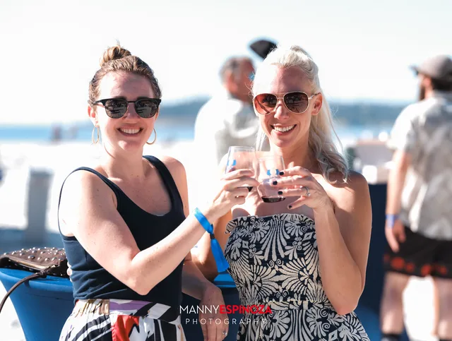 Two women in sunglasses toasting at Walk for Freedom 2026 on Carmel Beach