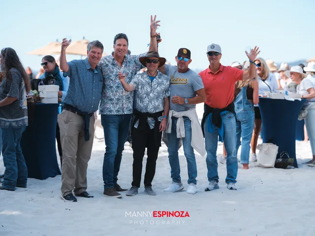 A group of guests waving to the camera on the beach at Walk for Freedom 2026 on Carmel Beach